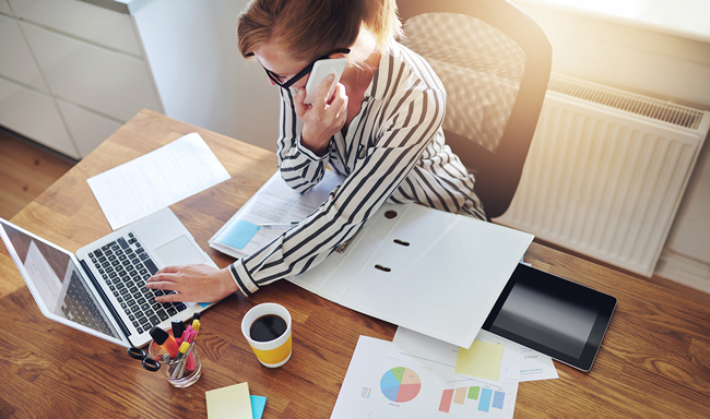 businesswoman inserting data into an infographic on her laptop