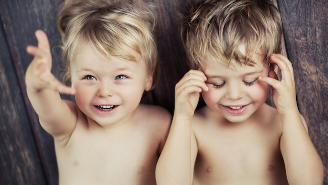 Two toddlers playing on their backs